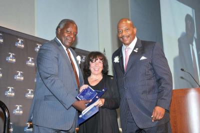 Gail Hobin (center) with UMass Boston Chancellor Dr. J. Keith Motley, right, and Vice-Chancellor Charlie Titus. 	Harry Brett photo